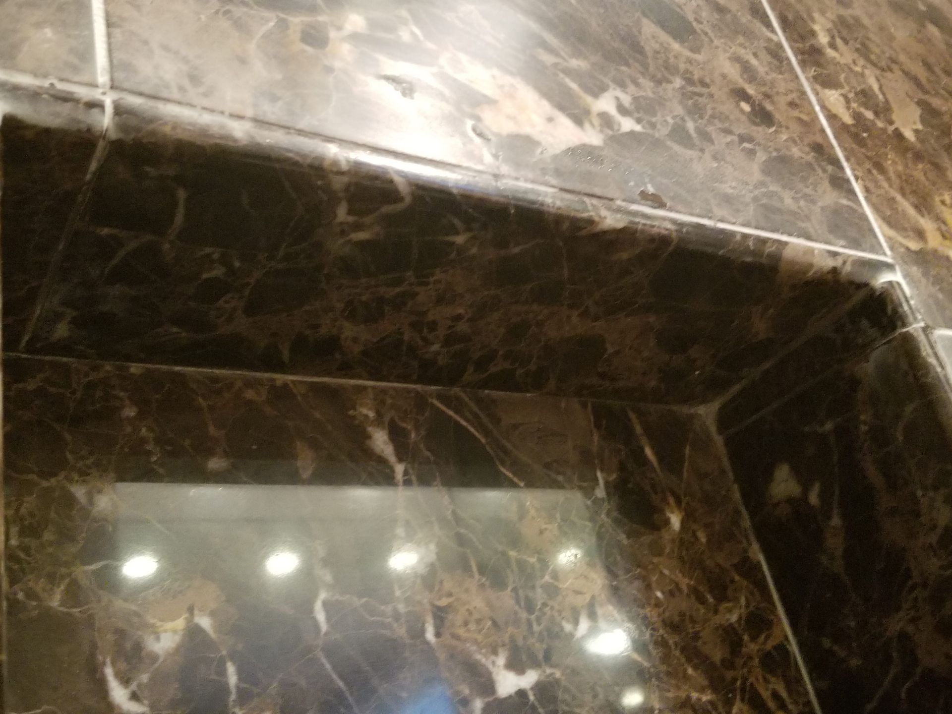 Same marble shower corner after cleaning, with the soap scum gone and the dark stone and polish restored, Needham MA