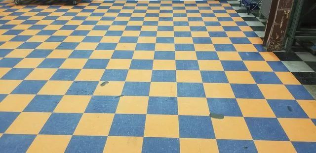 Same VCT floor after cleaning, with the original orange and blue colors showing again