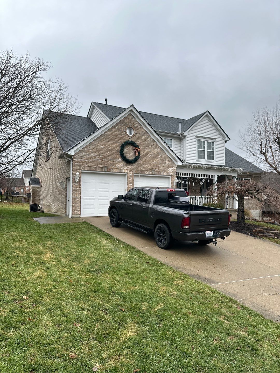 Suburban house with a holiday wreath and black pickup truck in the driveway
