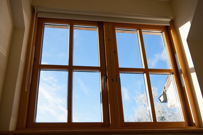 Wooden-framed window with blue sky visible through clear glass panes