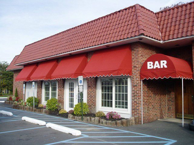 Exterior of a red brick building with red awnings and a