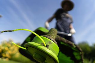 A person is using a lawn mower to cut the grass.