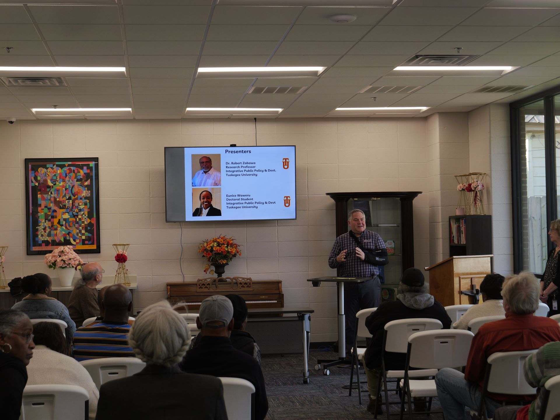 A man is giving a presentation to a group of people in a room.