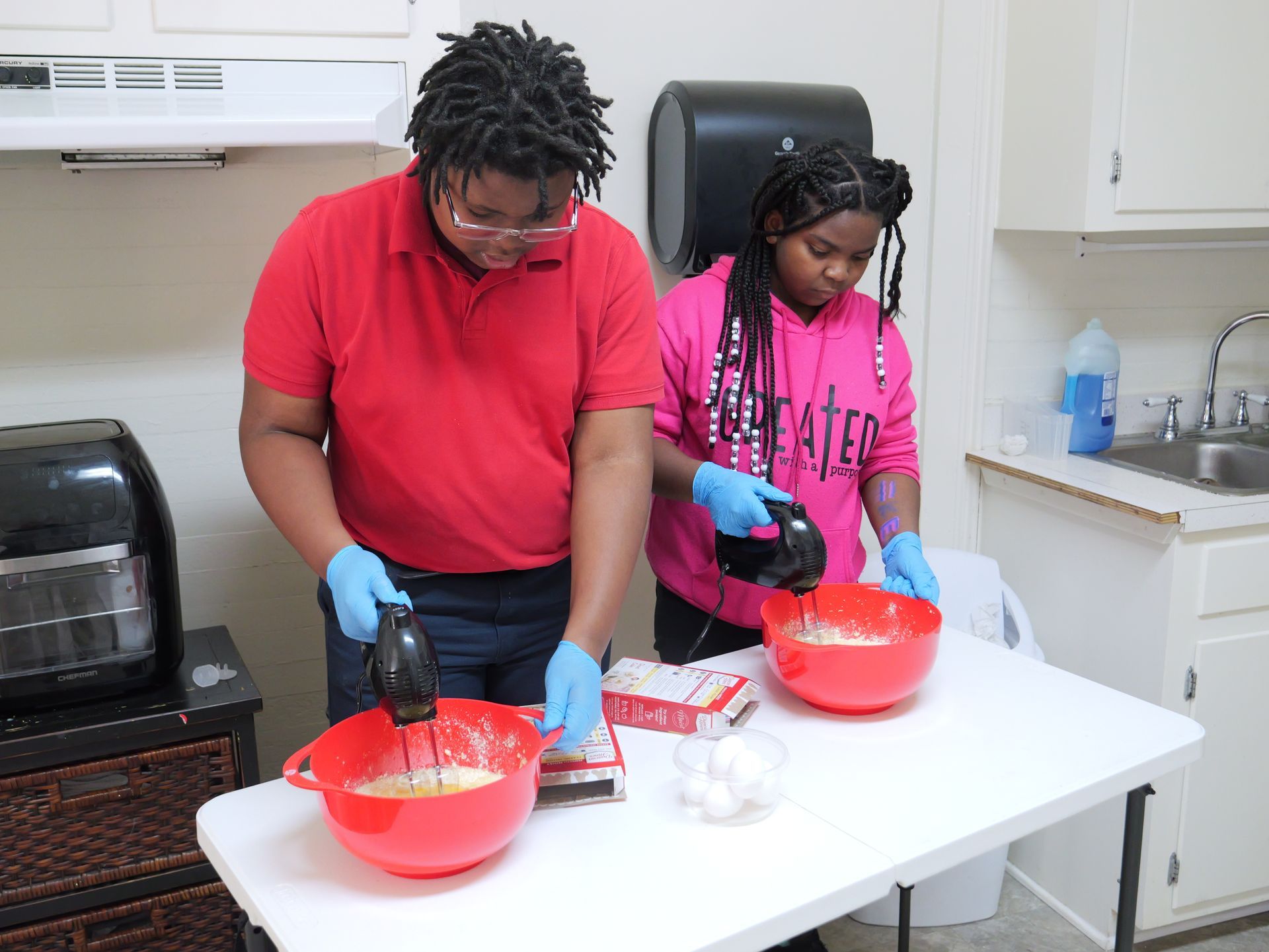 A man and a woman are preparing food in a kitchen.