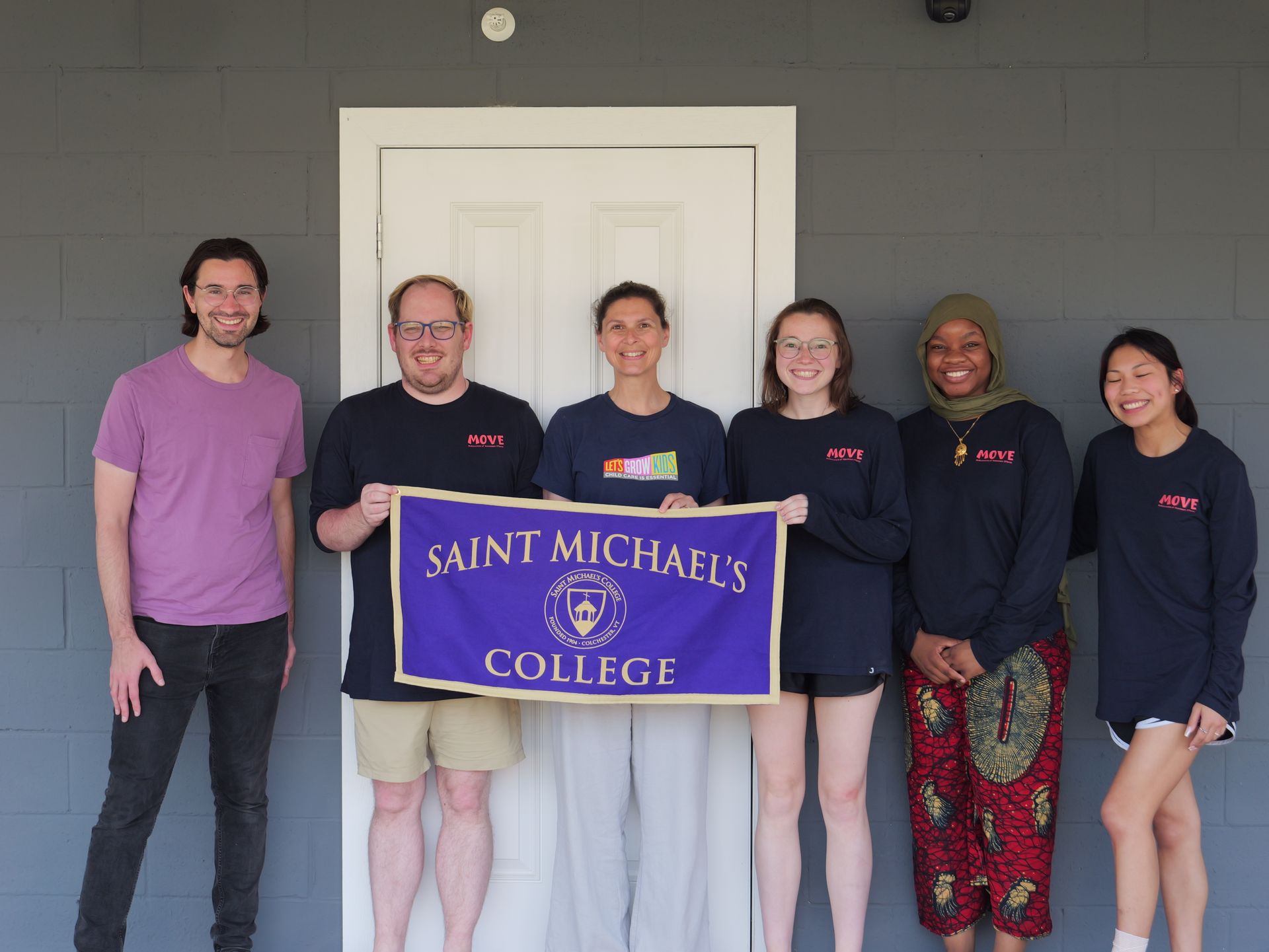 A group of people holding a banner that says saint michael 's college