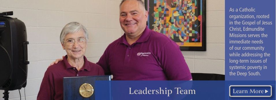 A man and a woman are standing next to each other holding a medal.