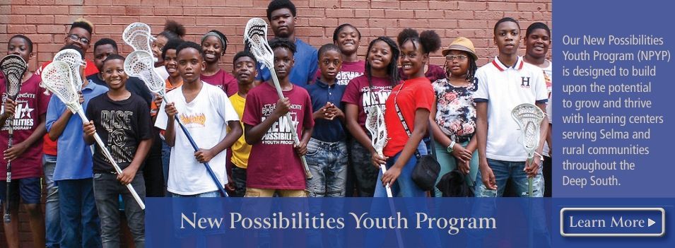 A group of young people are posing for a picture in front of a brick wall.