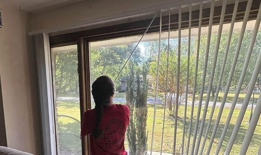 A Simmonds family member is installing vertical blinds for a customer.