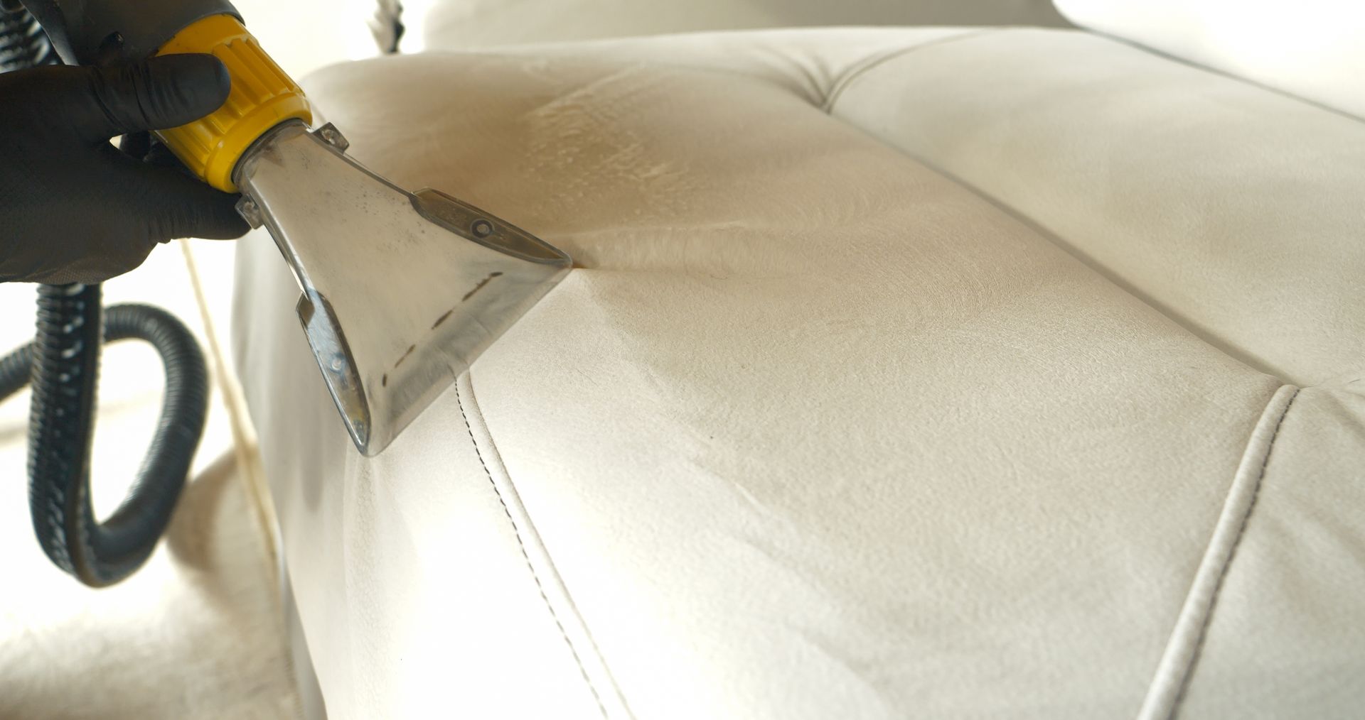 A light gray fabric sofa accented with yellow and white throw pillows.