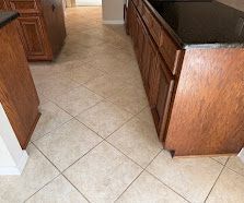 Tile-floored kitchen with wooden cabinets and a dark countertop.