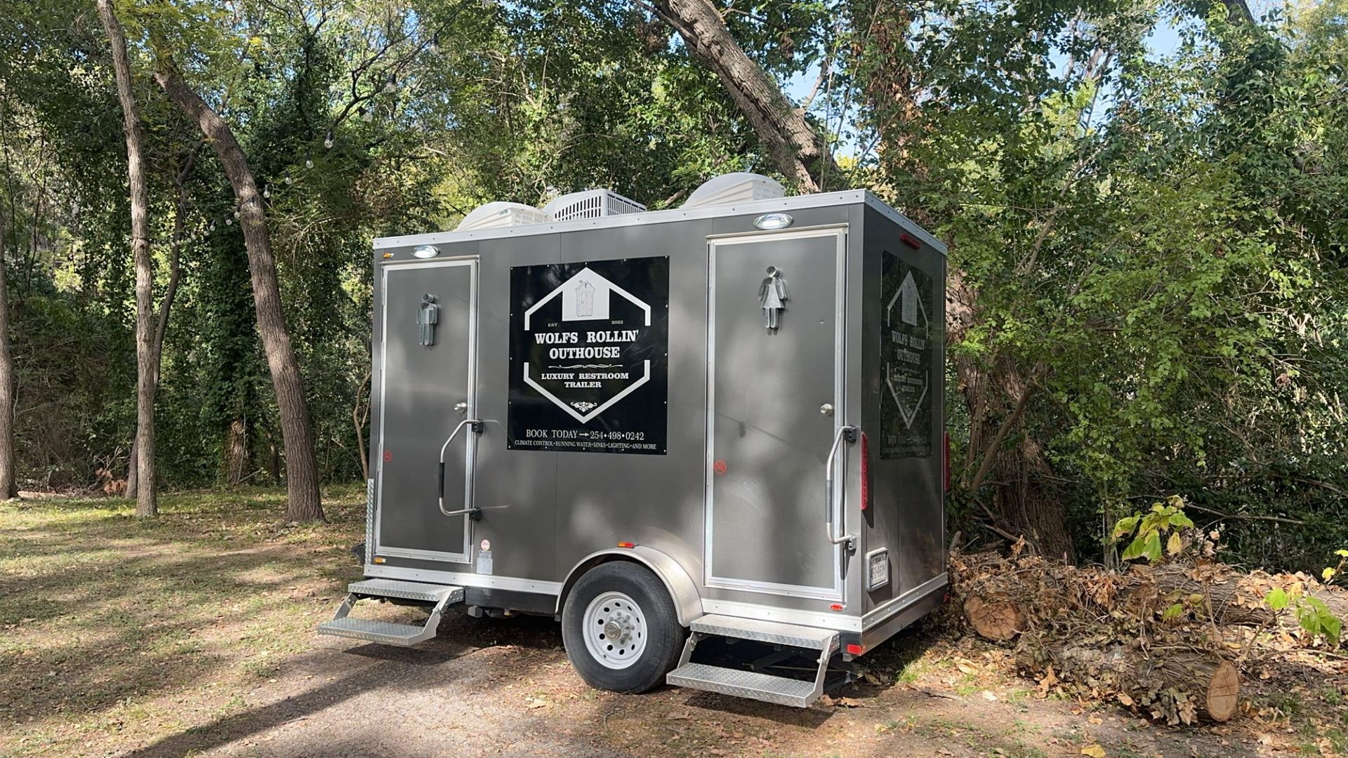 A trailer is parked in the middle of a forest.