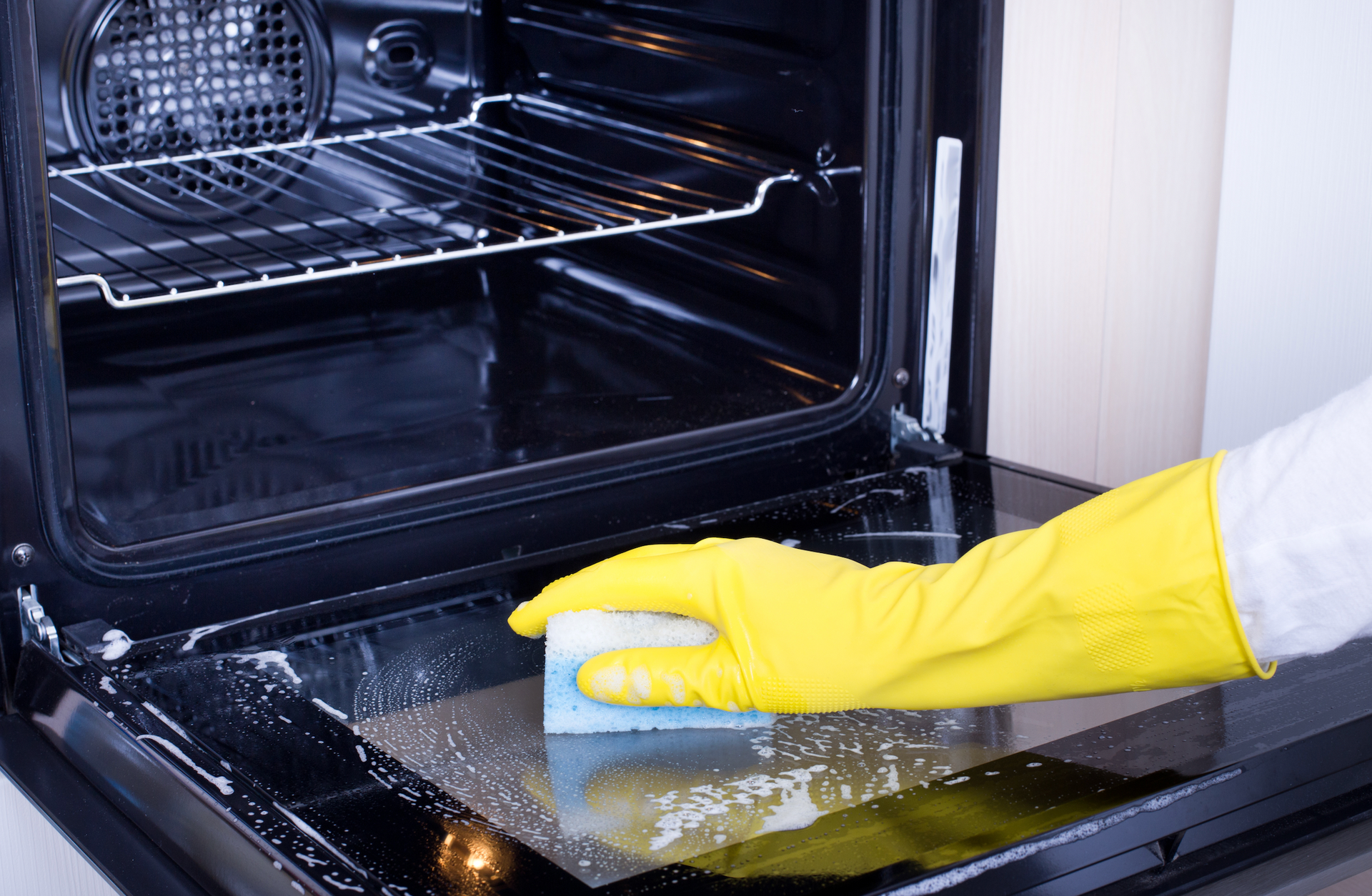 Cluttered garage with storage shelves and tools on concrete floor; white walls, garage door.
