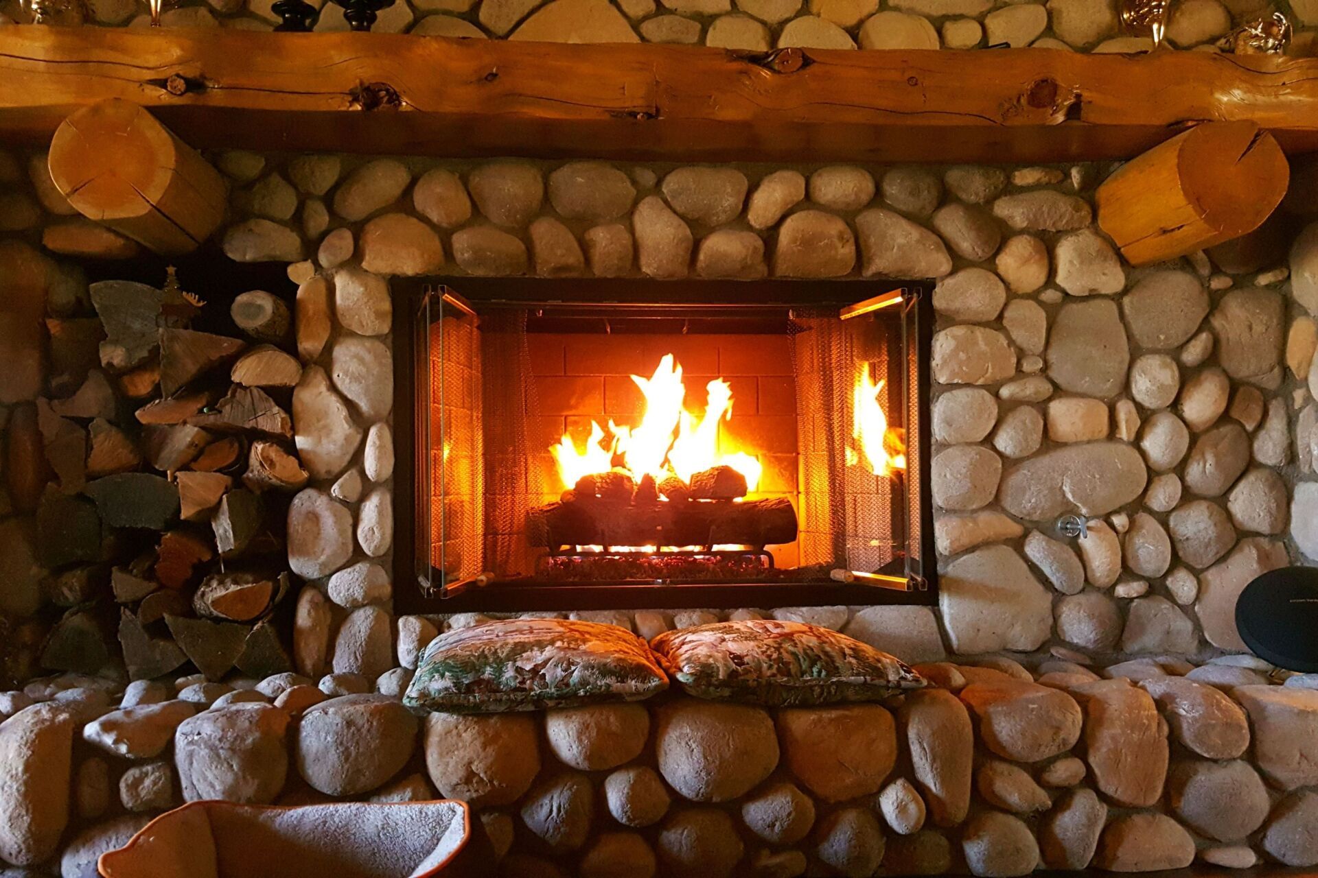 There is a fireplace in the middle of a stone wall.