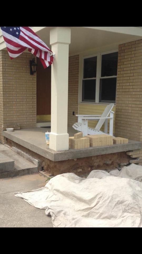 A porch with a rocking chair and an american flag
