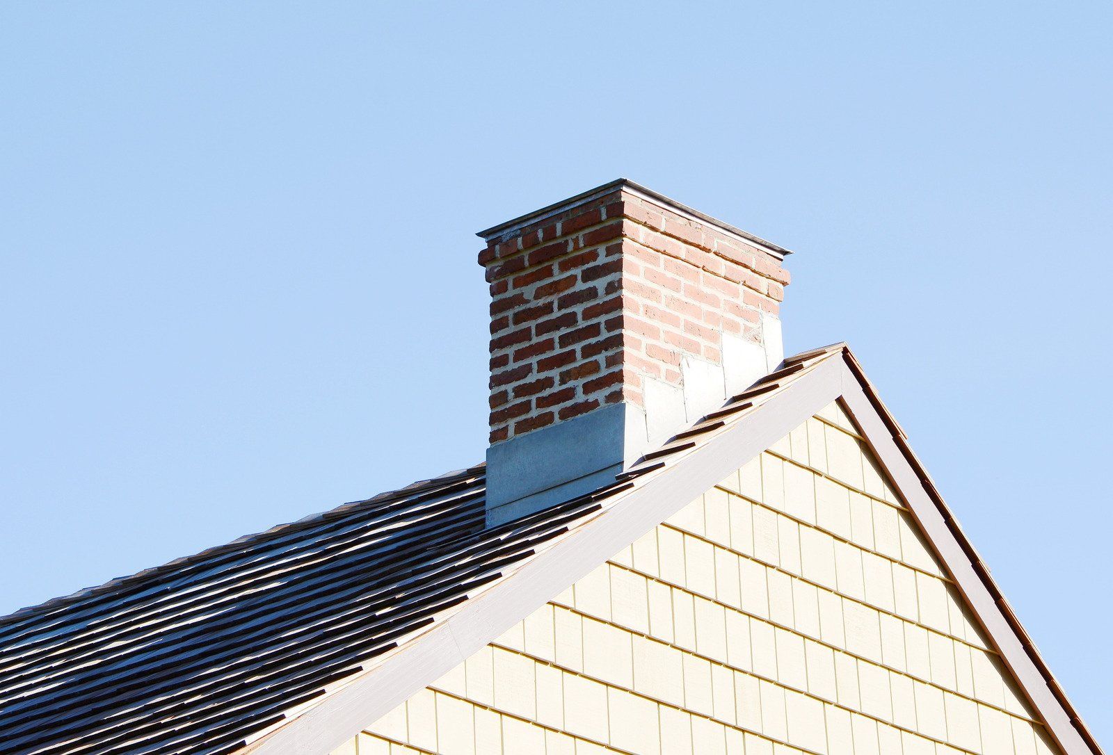 A brick chimney on the roof of a house