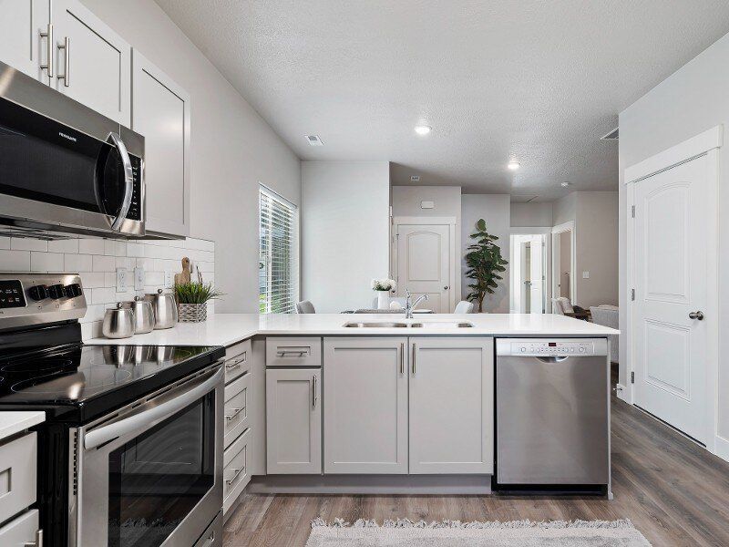 Bright modern white kitchen with stainless steel appliances and island.