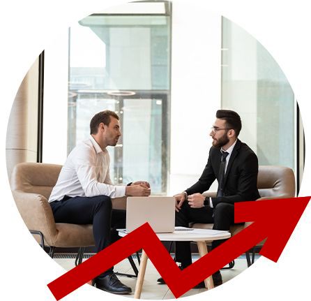 Two men are sitting on a couch talking to each other.