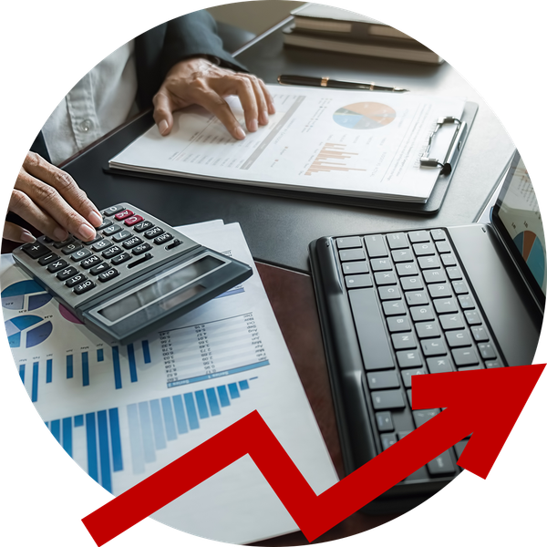 A person is using a calculator and a laptop on a desk.