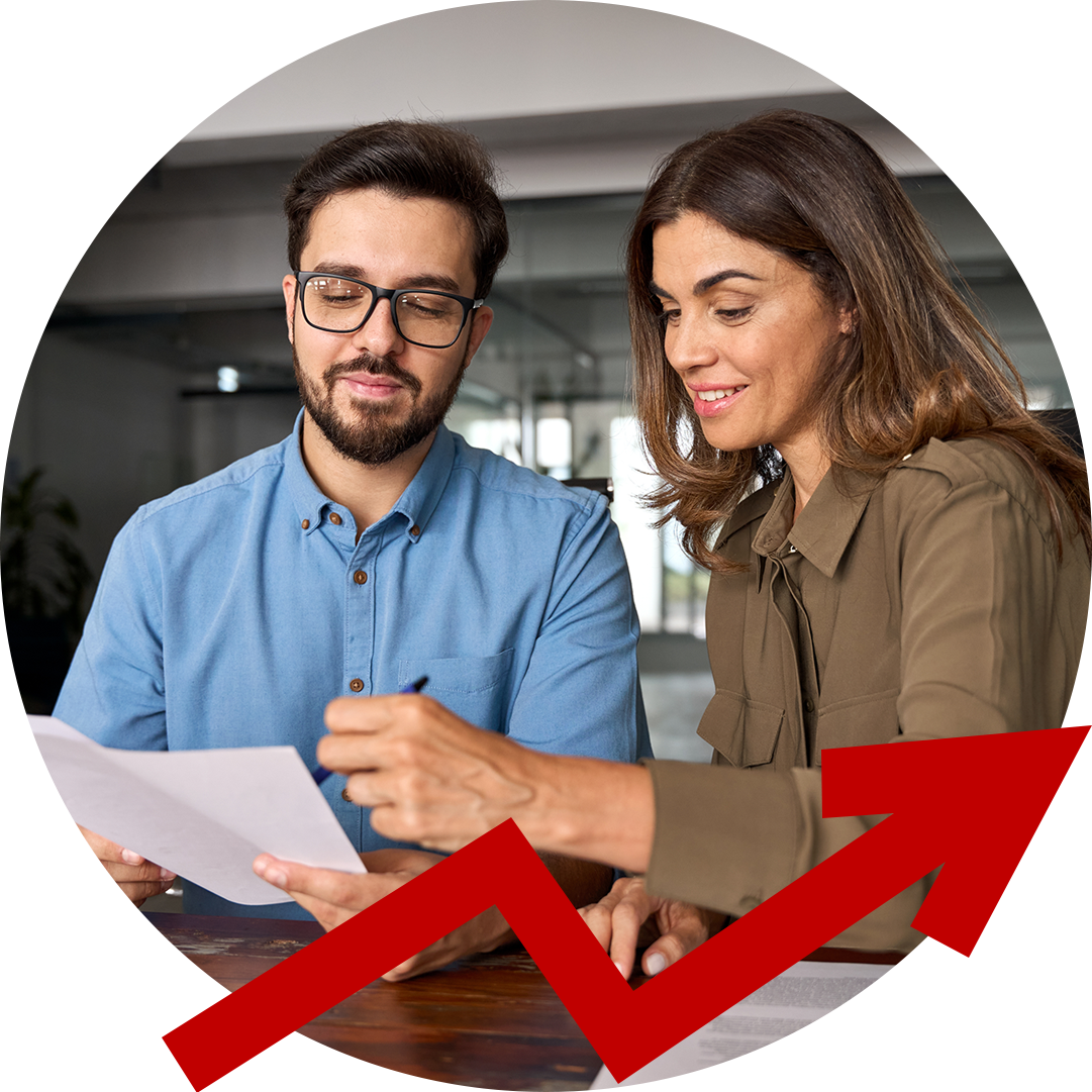 A man and a woman are sitting at a table looking at a piece of paper.