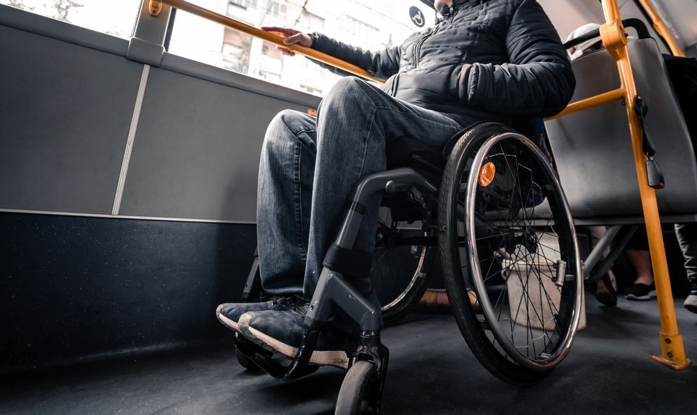 A Man in a Wheelchair is Sitting on a Bus — Collis Care In Dundowran, QLD