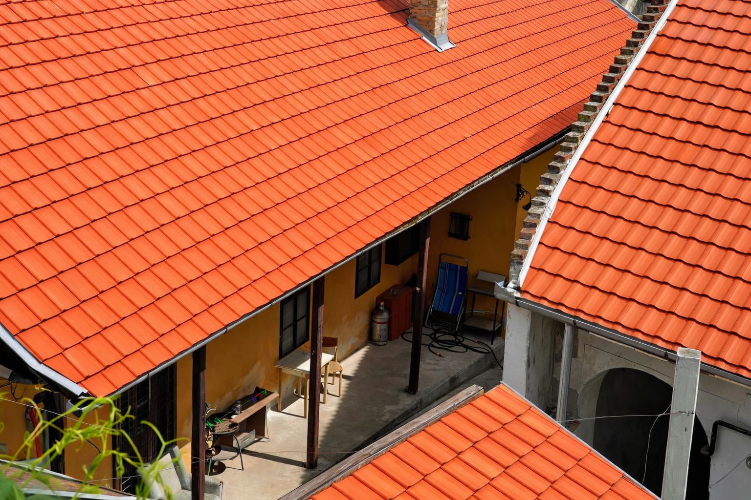 Overhead view of several orange-tiled rooftops surrounding a yellow building with an interior courtyard.