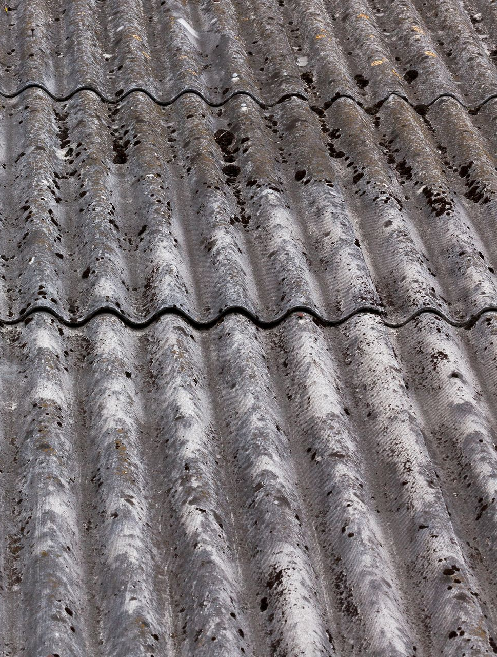 Gray, weathered, corrugated roof tiles.