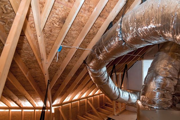 Interior view of an unfinished attic space with wooden framing and HVAC ductwork.