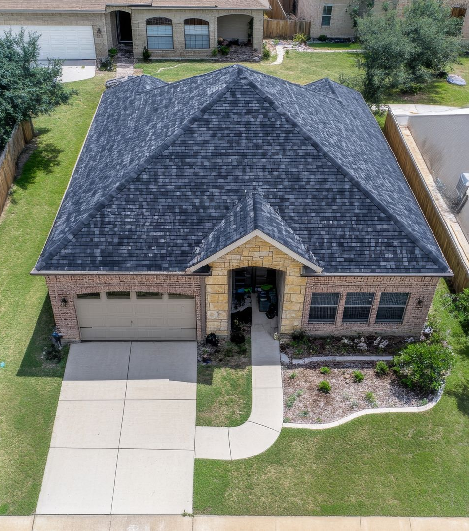 A single-story house with a brick facade, beige garage door, and gray roof.