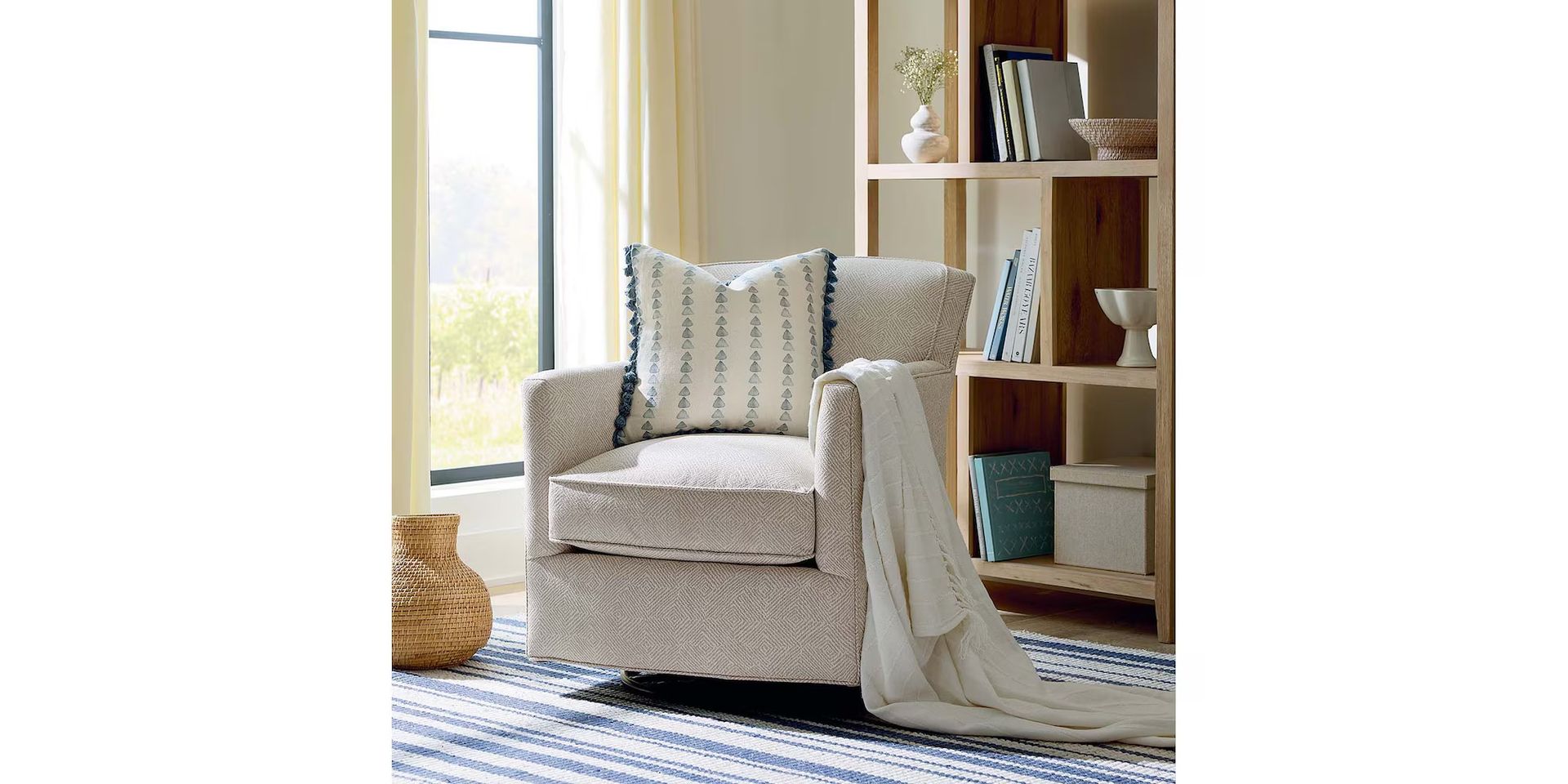 Cozy living room with patterned armchair, throw blanket, patterned rug, and wooden bookshelf.