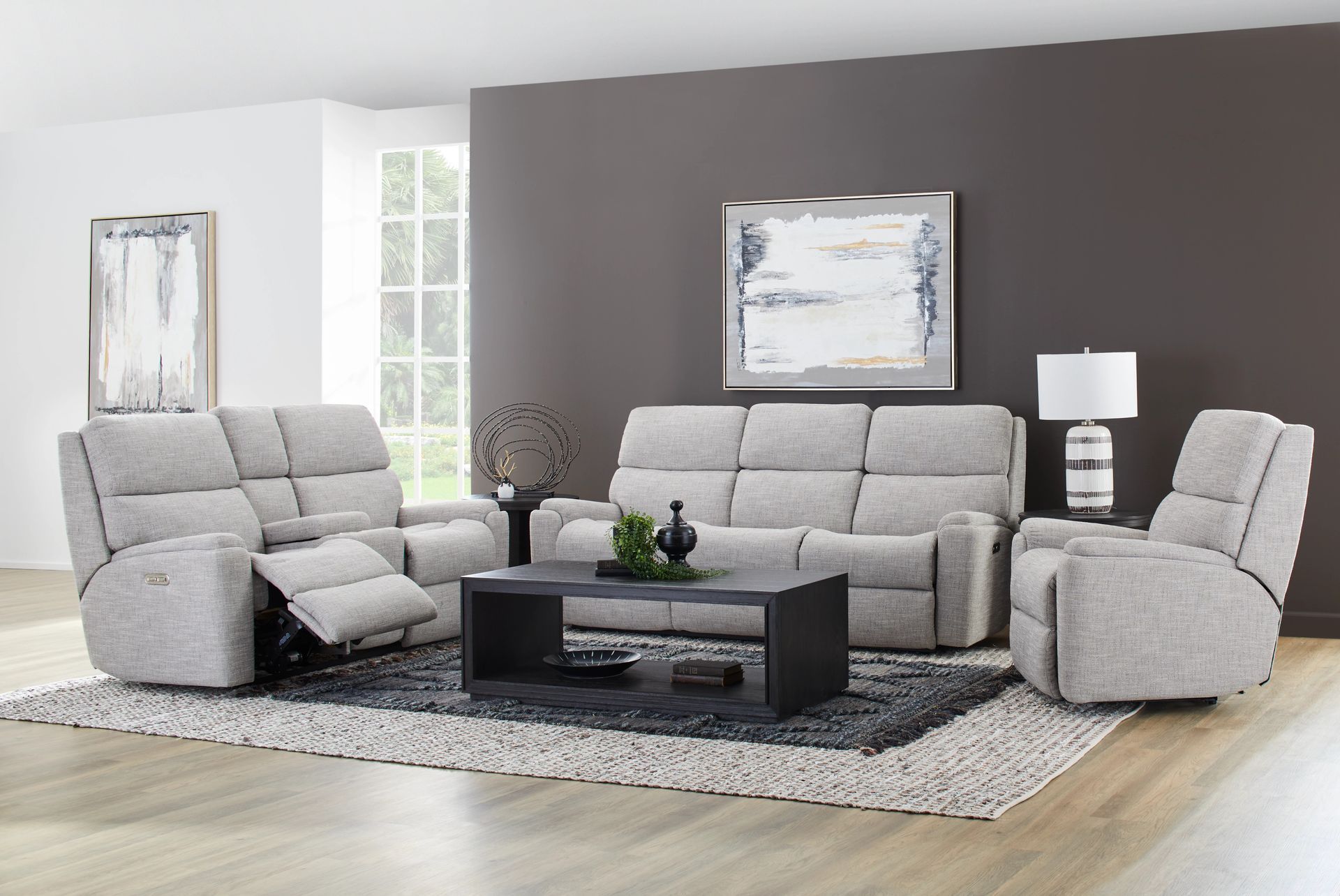Living room with gray sofa set, recliner, coffee table, and artwork.