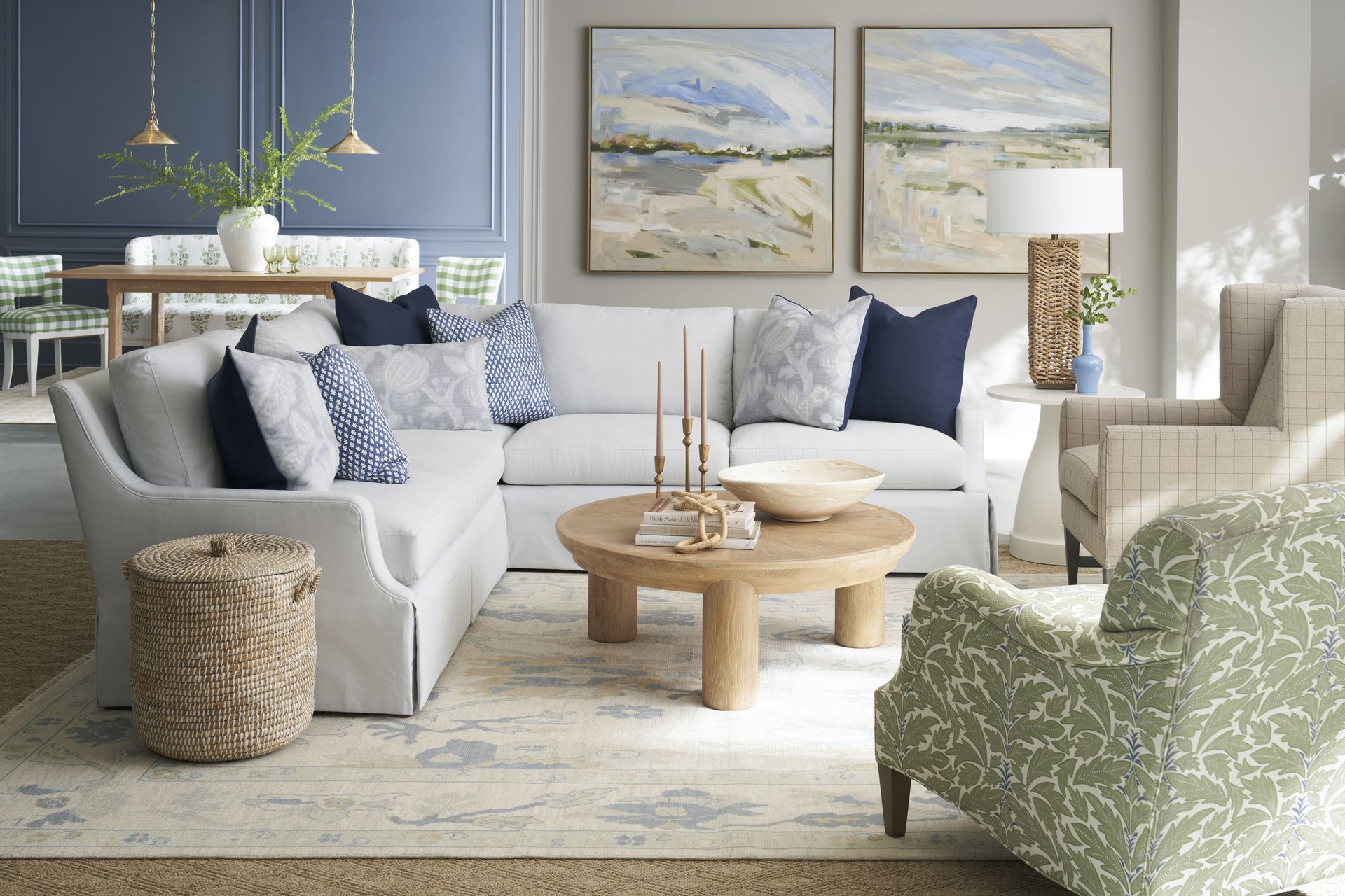 Living room with blue walls, sectional sofa, art, and patterned chair.