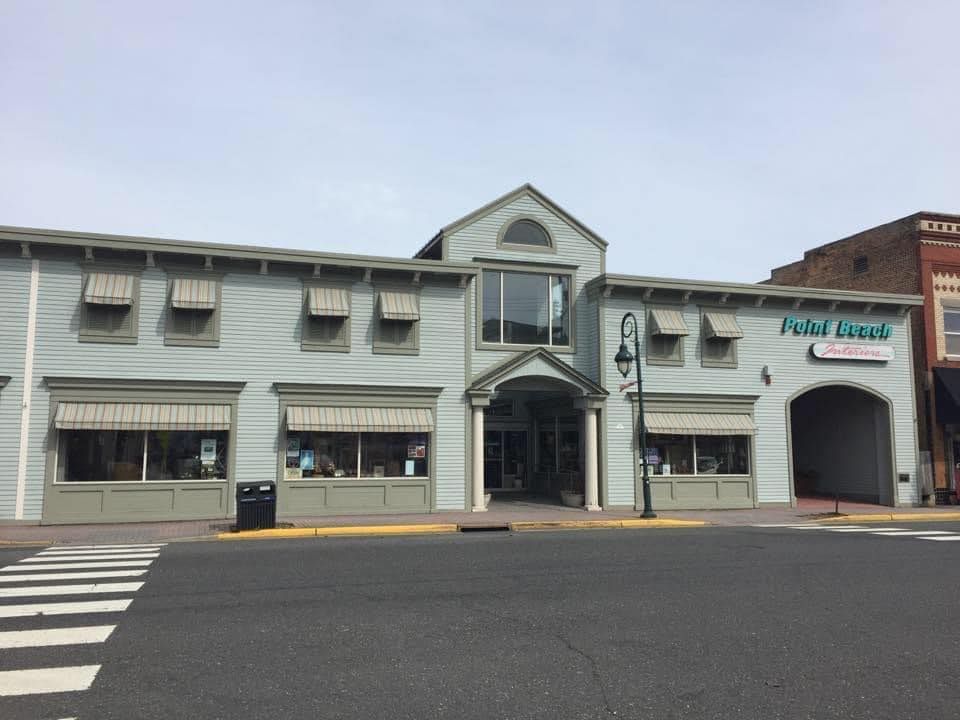 Two-story light blue building with awnings and
