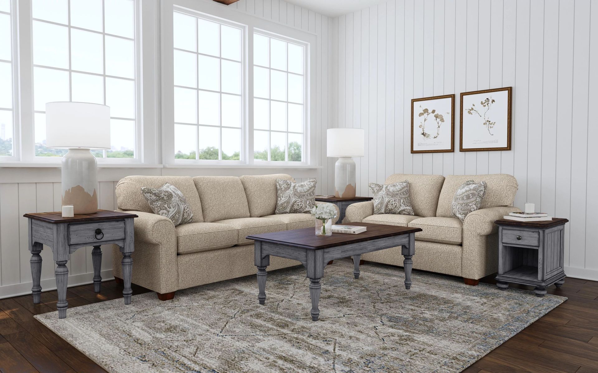 Living room with tan sofas, blue-gray tables, large windows, and a patterned rug.