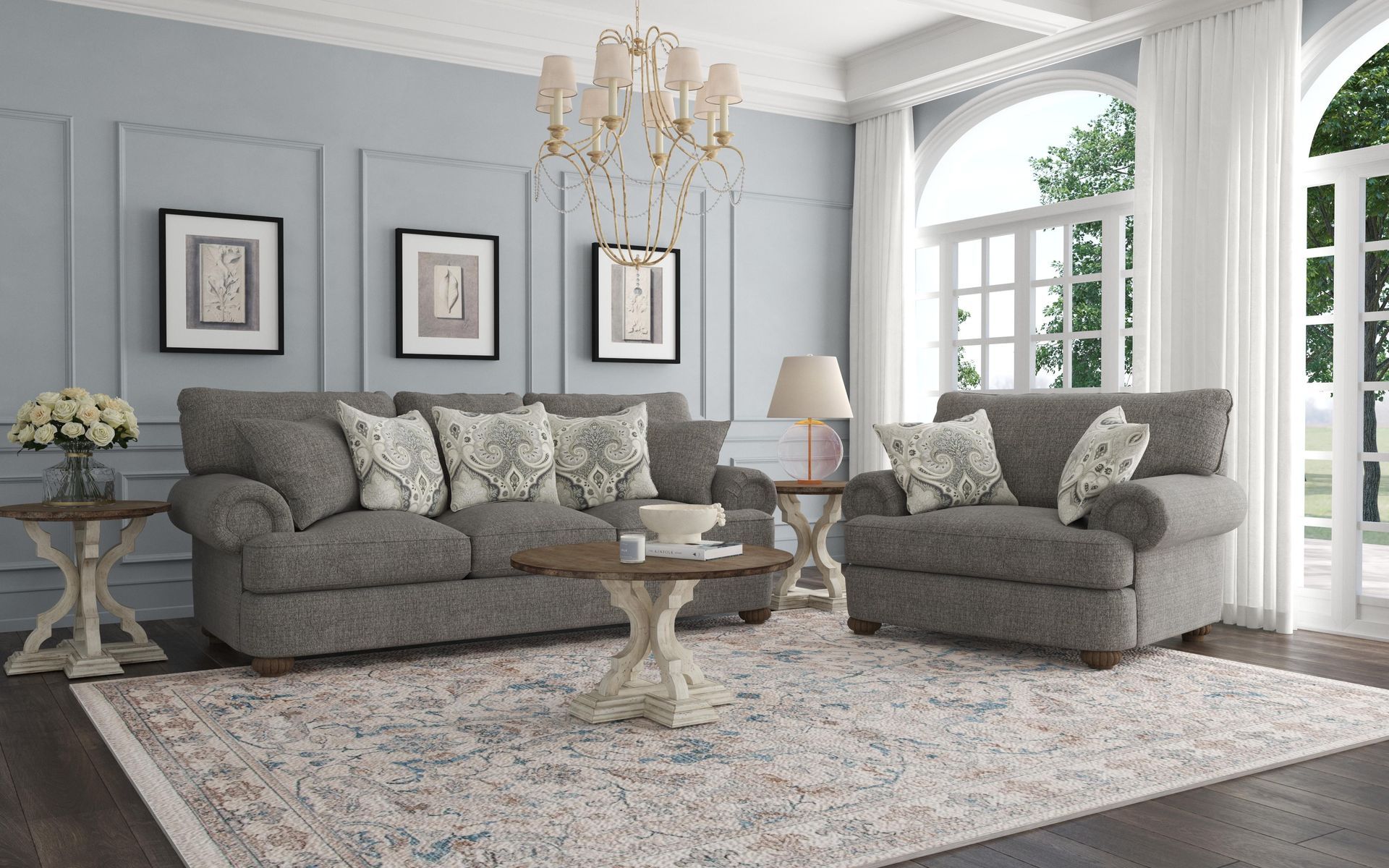 Living room with gray sofa, chair, rug, and coffee table against blue wall with chandelier.