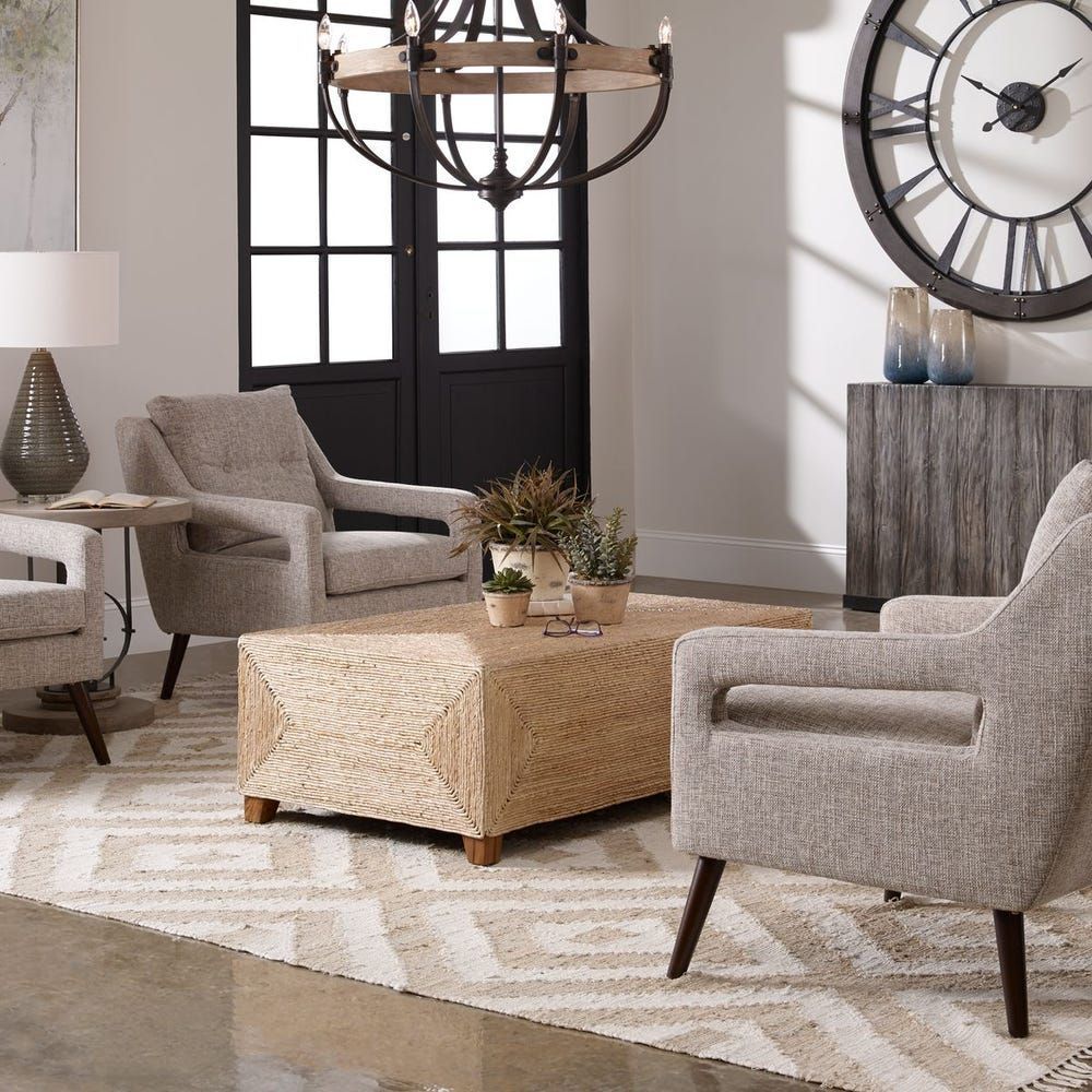 Living room with neutral furniture, large rug, and decorative clock.