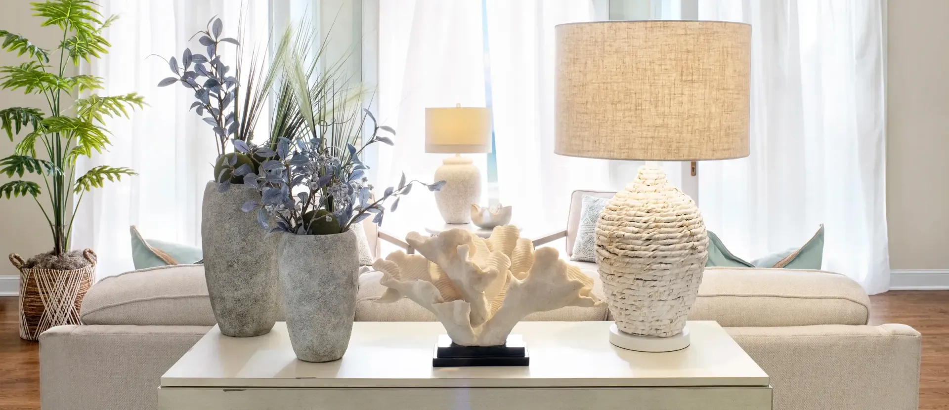 Living room with white sofa, lamps, vases, and coral decor.
