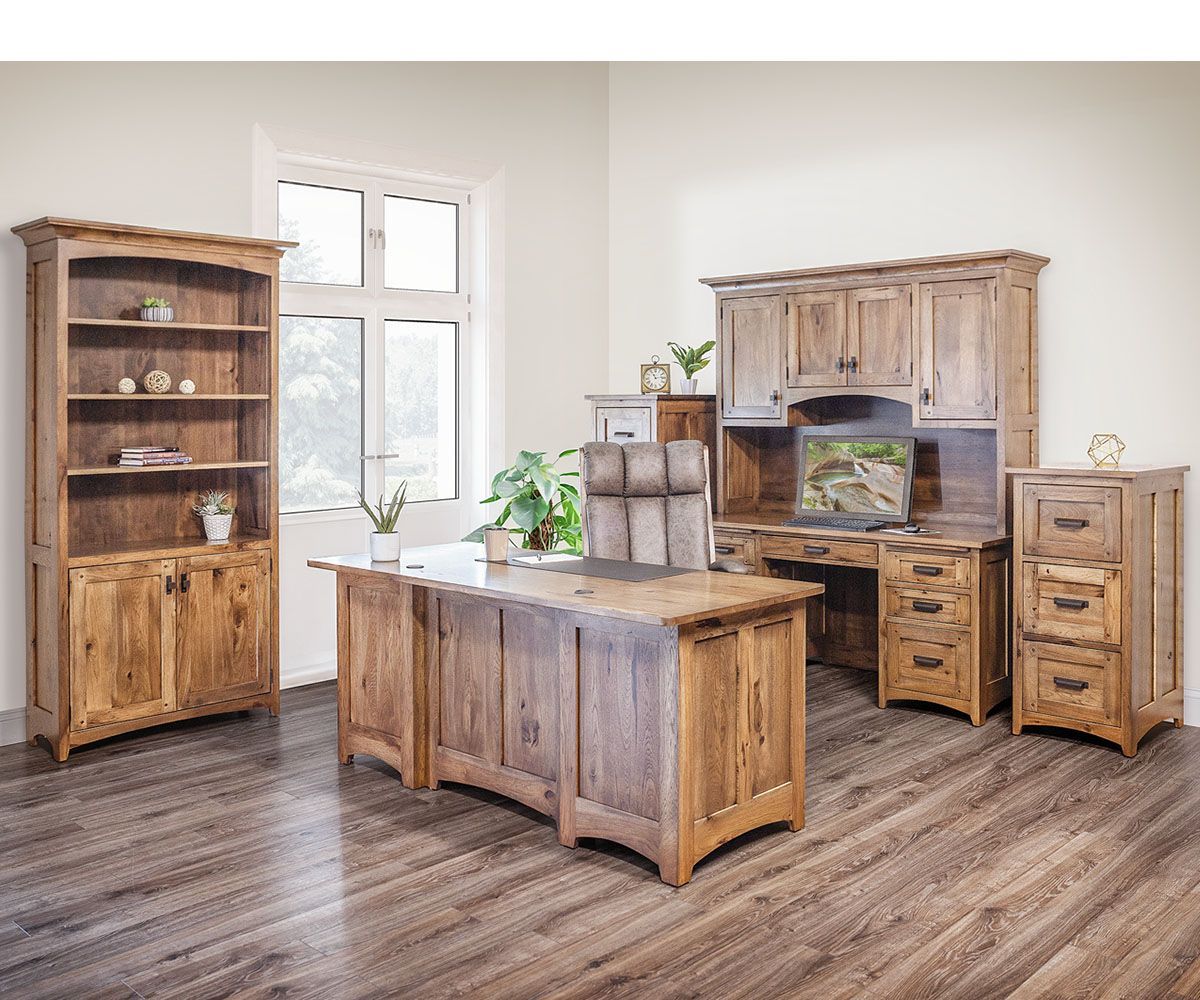 Rustic wooden office furniture set: desk, hutch, bookcase, and file cabinet in a bright room with a window.