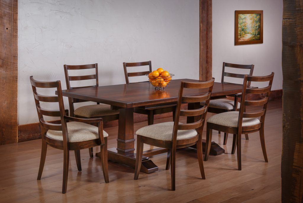 Dining room set with dark wood table, chairs, oranges, and framed art.