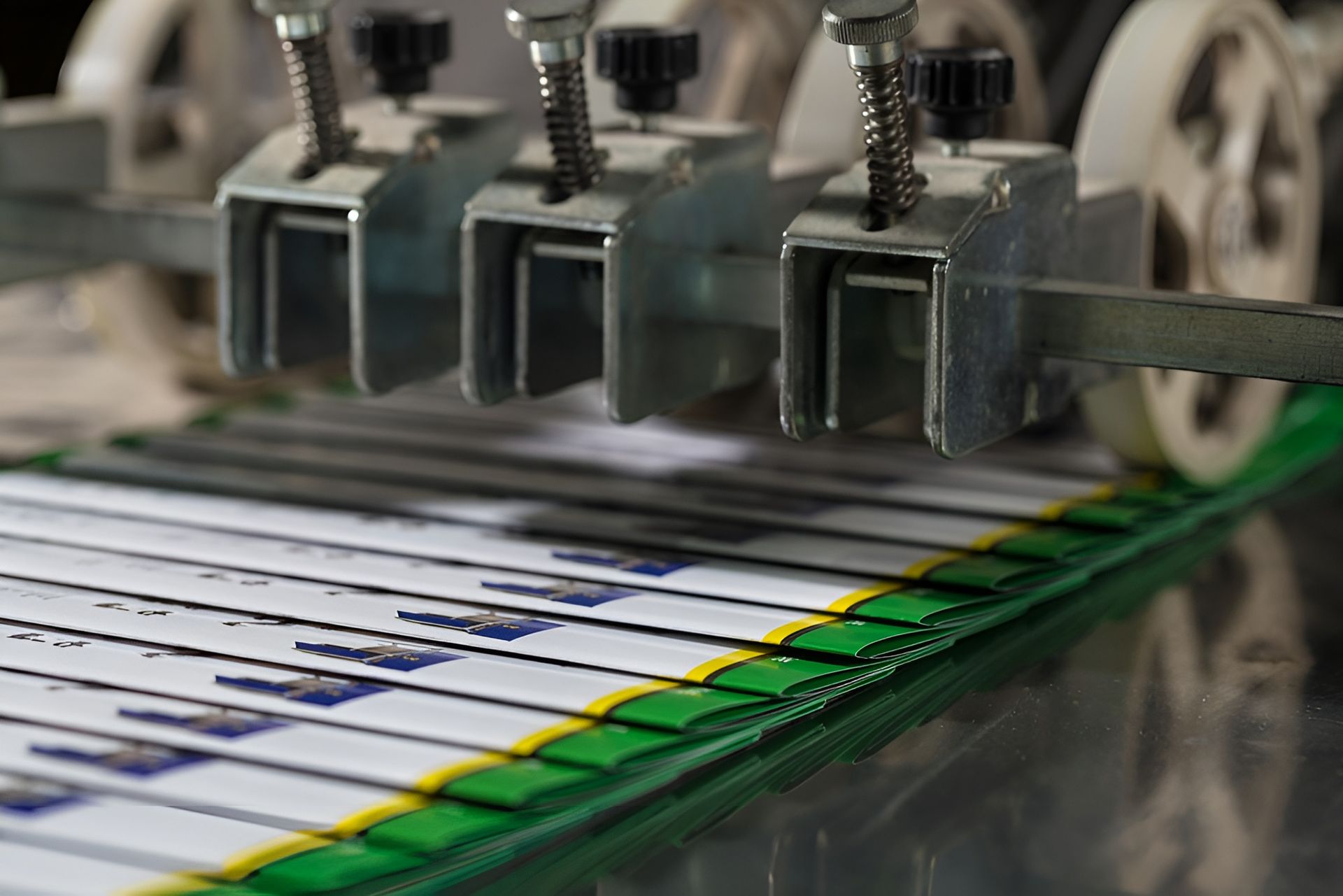 Machine Binding Documents, Metallic Parts Pressing Down on Green and Yellow Striped Pages — Digi Print Pro in Bangalow, NSW