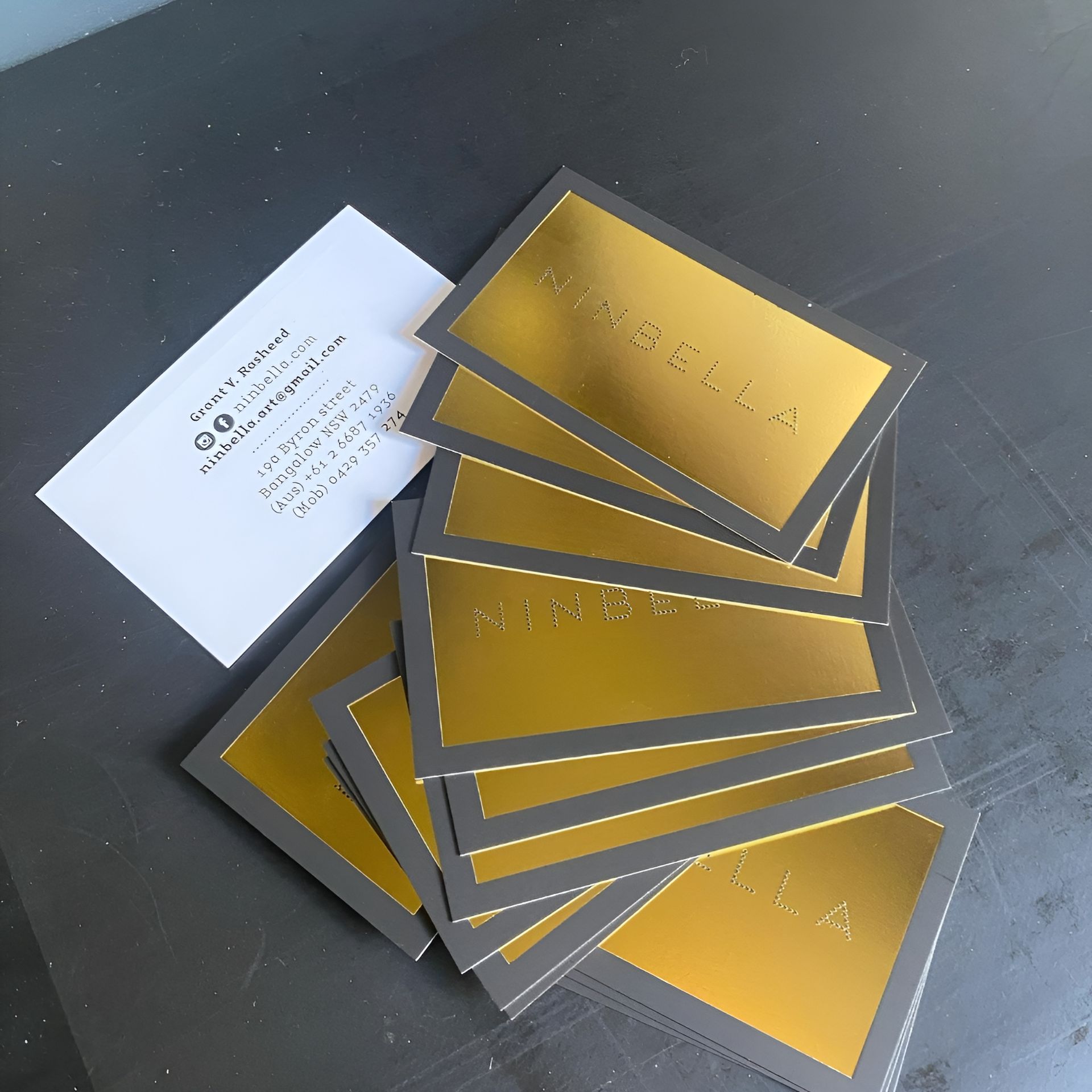 Pile of Gold and Black Business Cards with A White Information Card — Digi Print Pro in Brunswick Heads, NSW