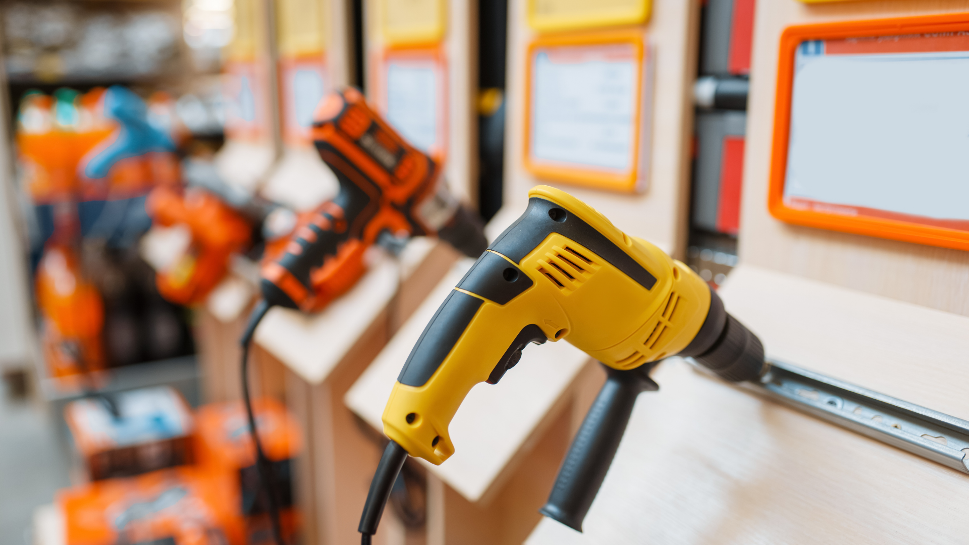 Yellow and black power drills displayed on a wall in a hardware store