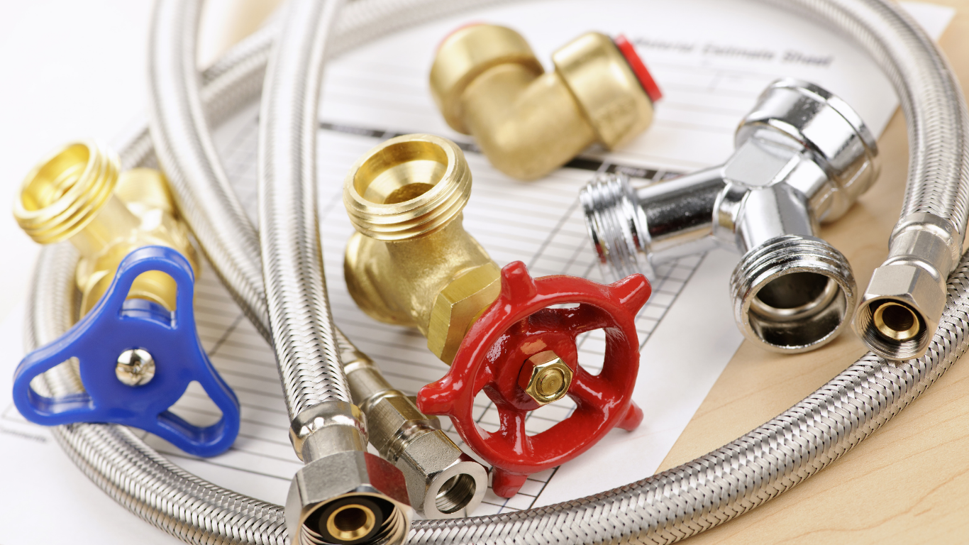 Assorted plumbing valves and braided metal hoses with colorful handles on a white background