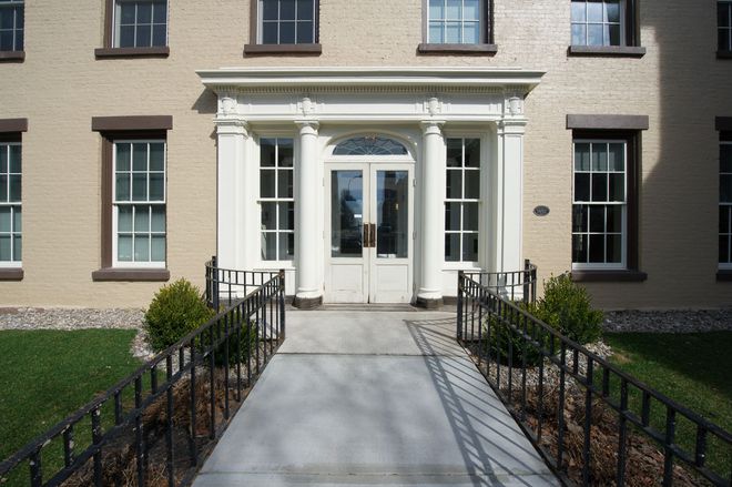 A brick building with a walkway leading to the front door