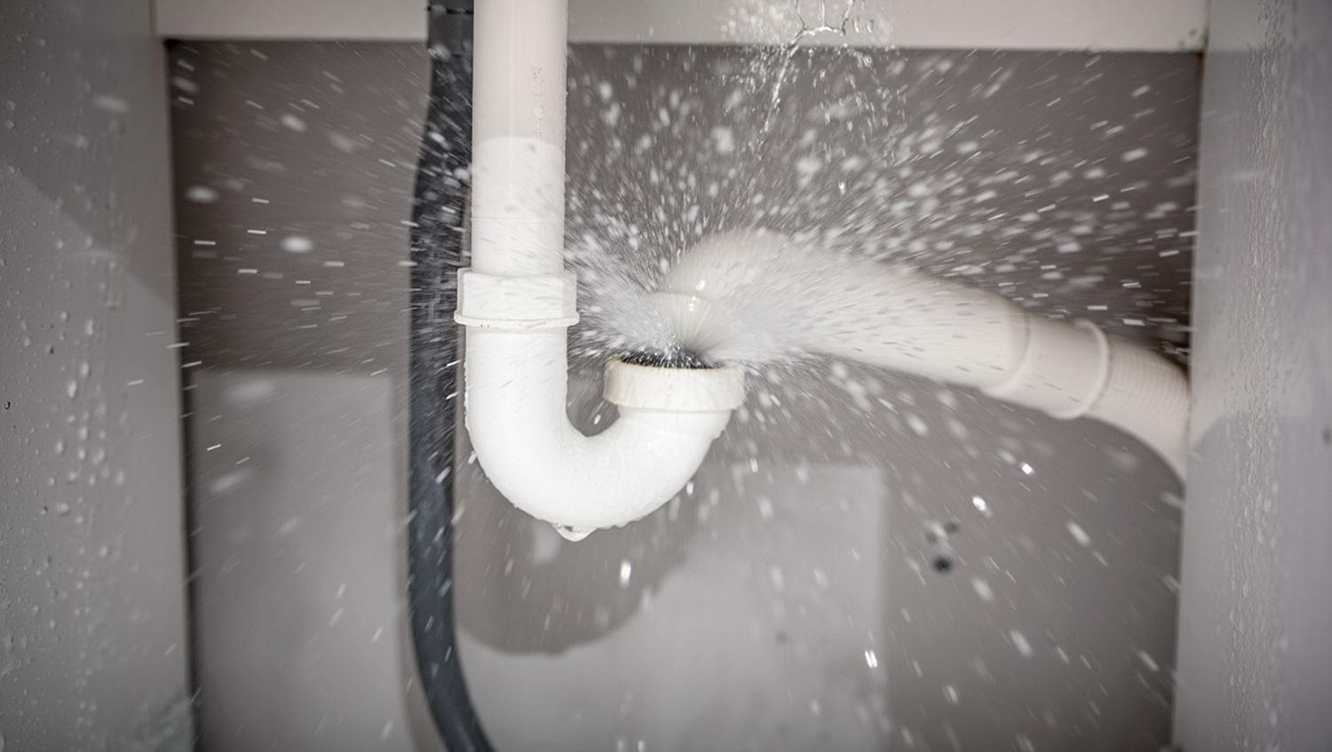 Water pipe bursting and spraying water causing a plumbing emergency.