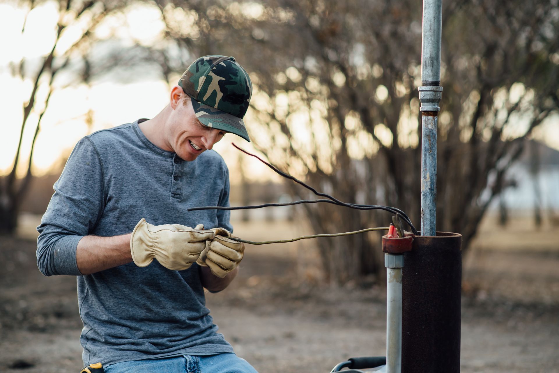 A man smiling while doing well work outside