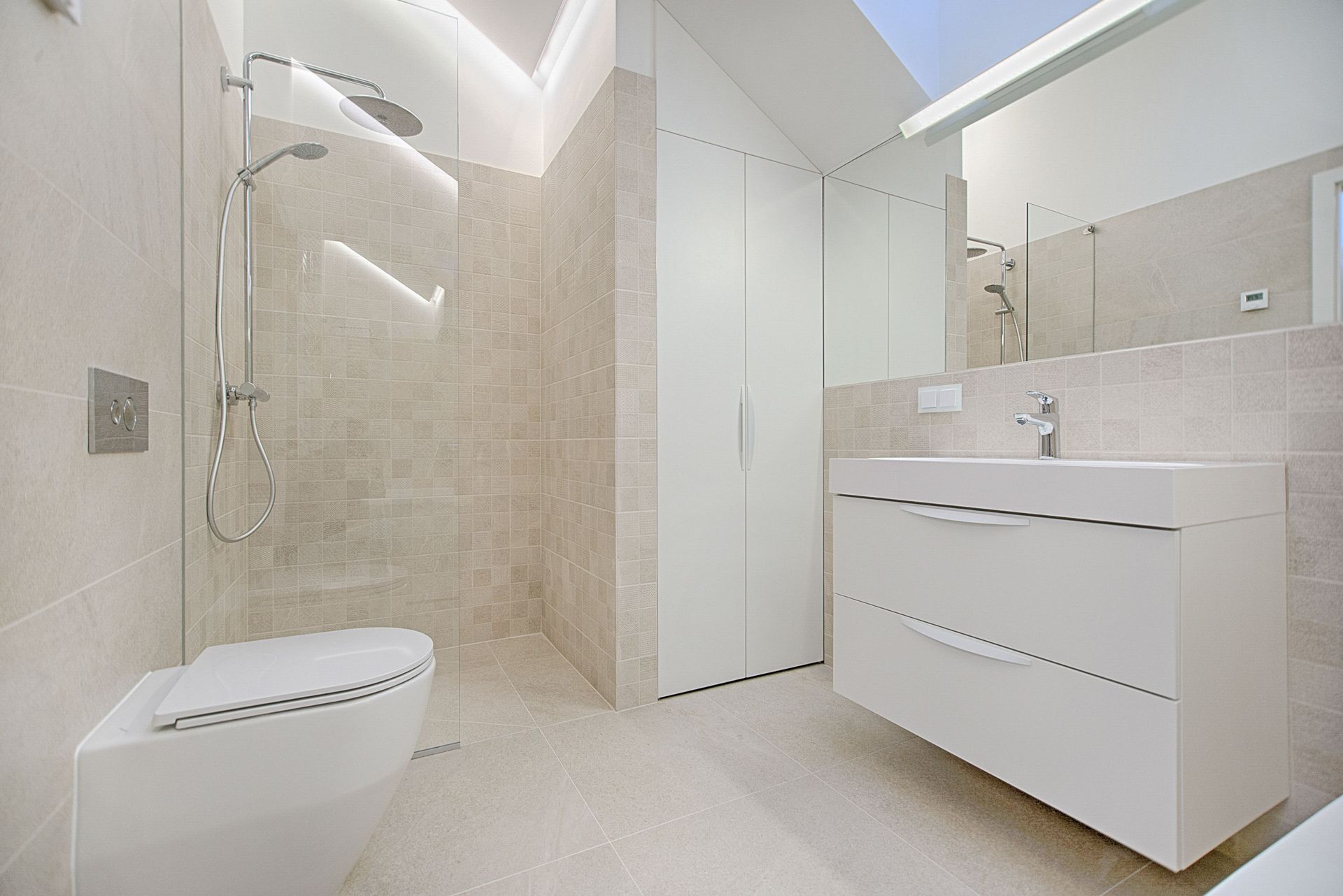 Modern white bathroom with walk-in shower, vanity, toilet, and skylight; bright tiled interior
