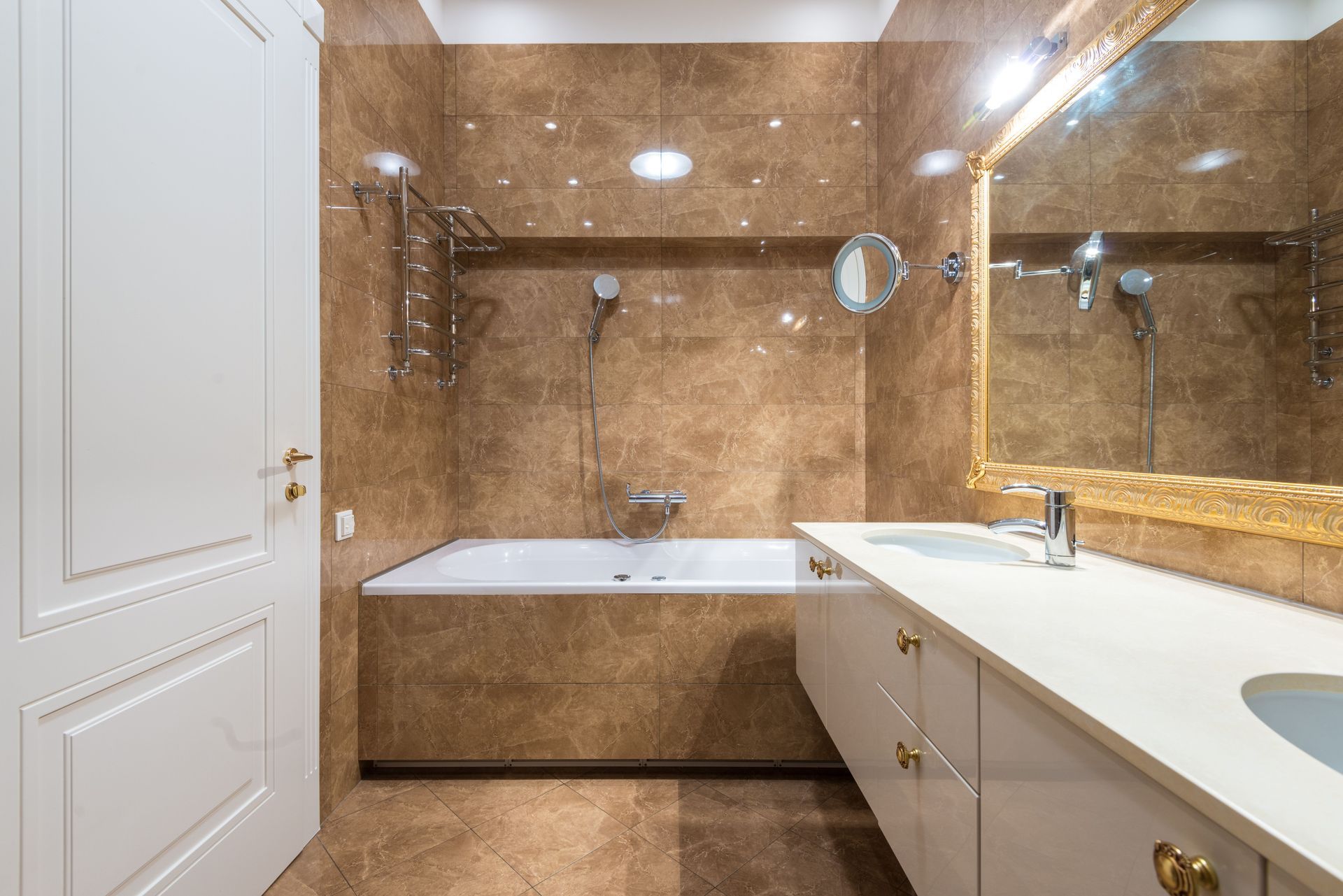 Spacious beige bathroom with a bathtub, vanity, large mirror, and glass shower enclosure.
