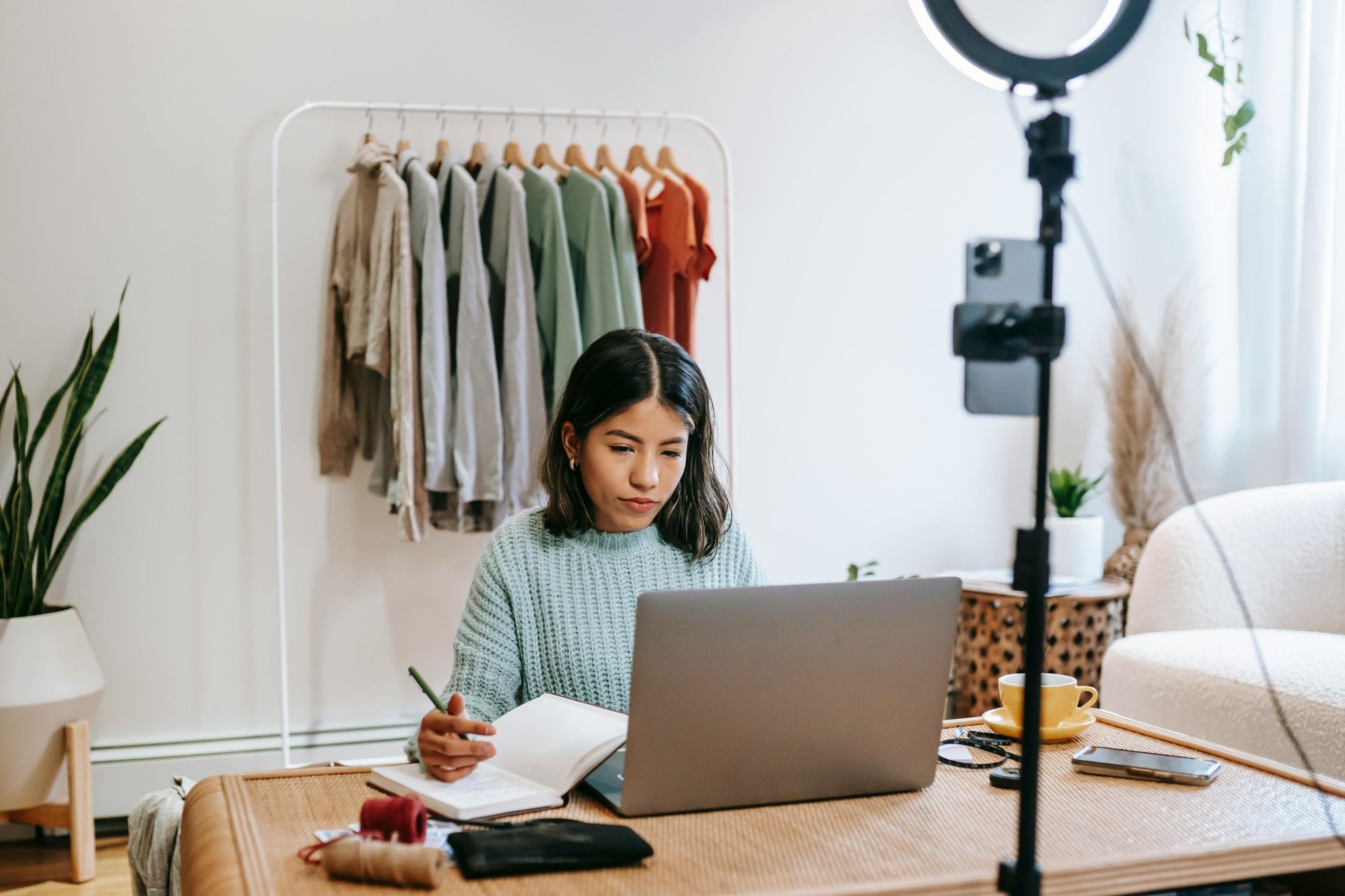 A woman is sitting at a table using a laptop computer.