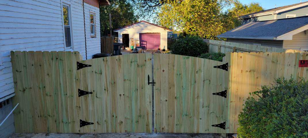A wooden fence is sitting in front of a house.
