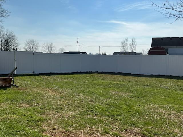 A backyard with a white fence and a swing.